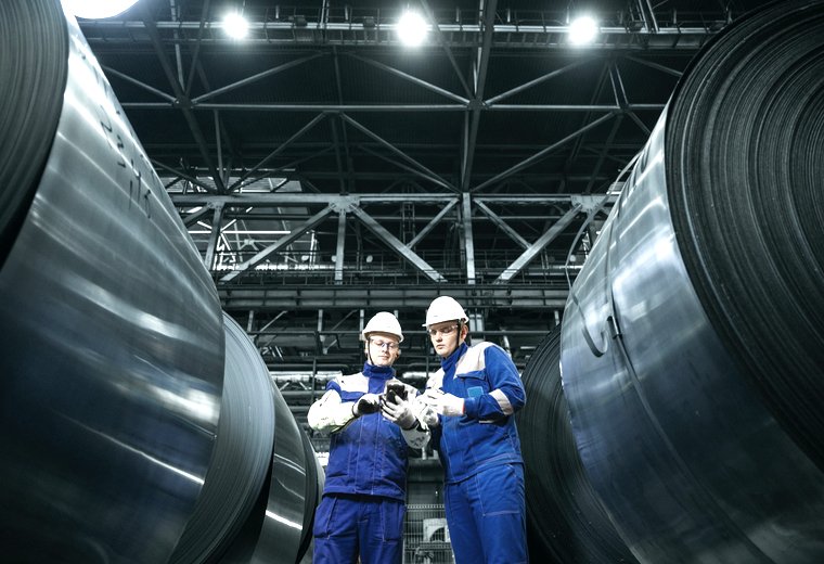 Factory floor · two workers beside steel coils, application reference